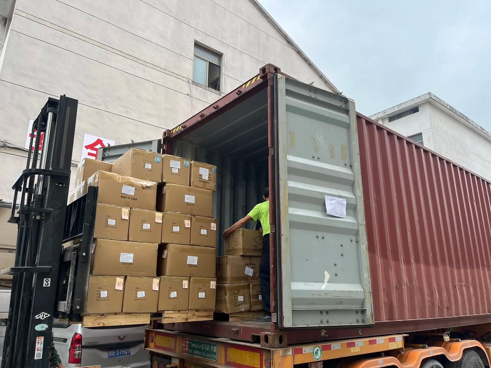 Forklift loading packed cartons into an export shipping container